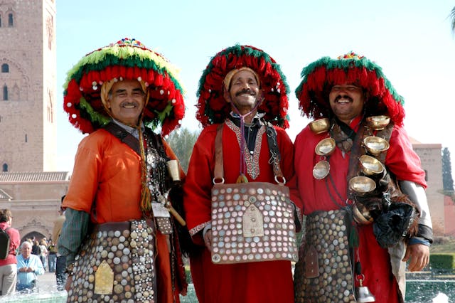 Tres hombres marroquíes sonriendo y dando la bienvenida a los visitantes